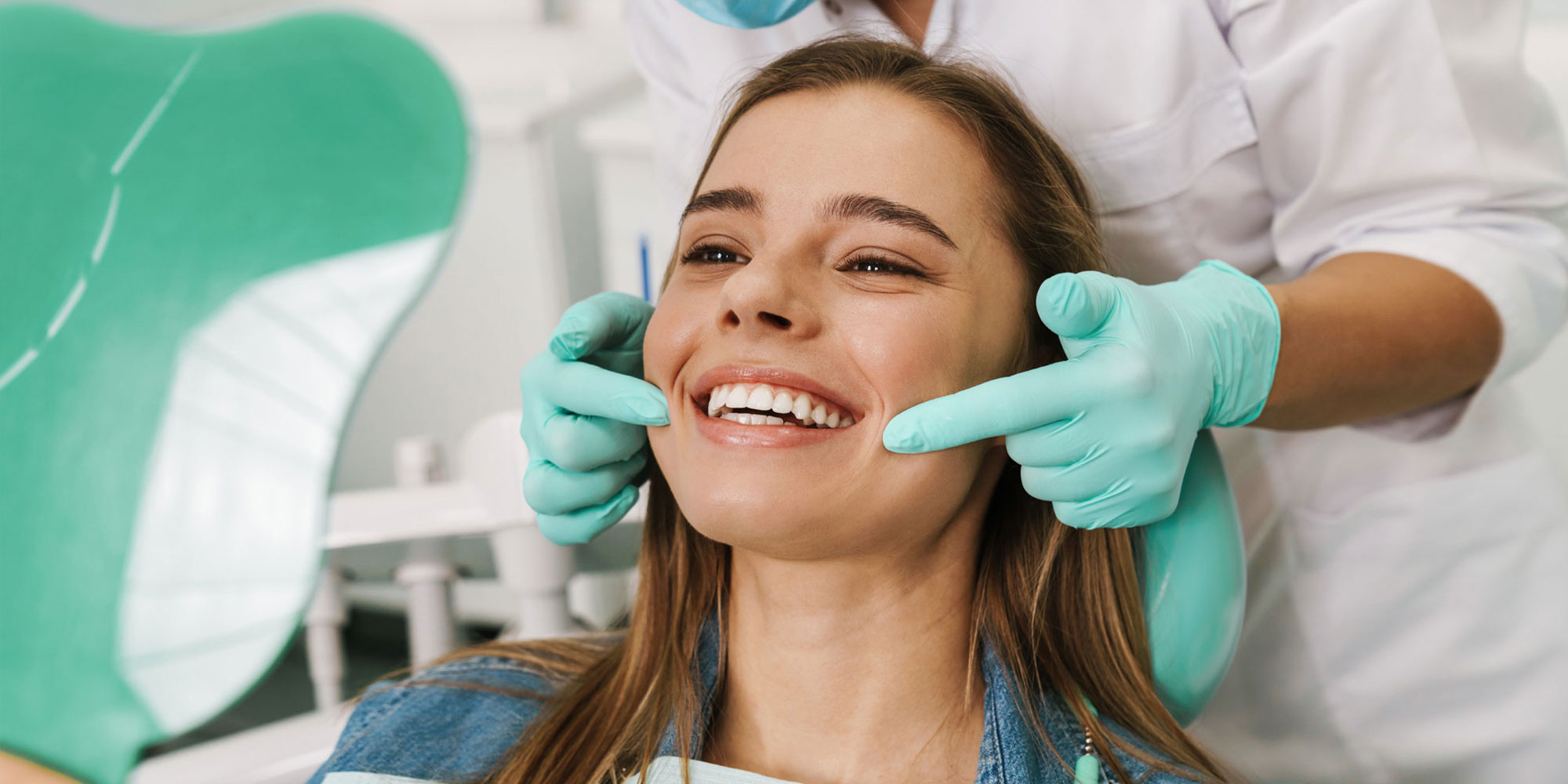 cosmetic dental patient after teeth whitening smiling into mirror