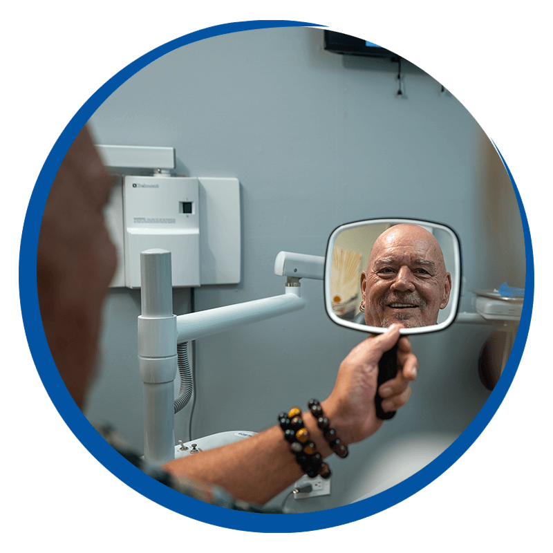 patient smiling looking at his new full mouth dental implants
