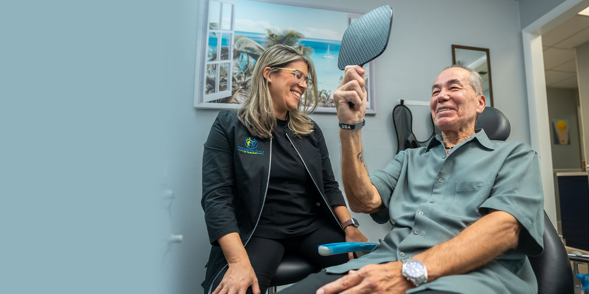 patient smiling into mirror looking at results of oral surgery treatment